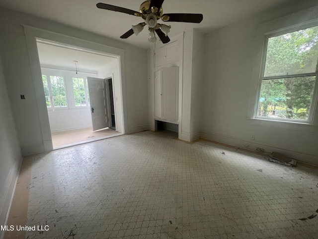 spare room featuring ceiling fan and a wealth of natural light