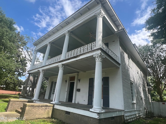 neoclassical home with ceiling fan, a porch, and a balcony