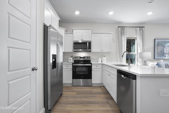 12278 Frazier Ln, Gulfport, MS 39503 - kitchen featuring stainless steel appliances, a sink, light countertops, white cabinets, and recessed lighting