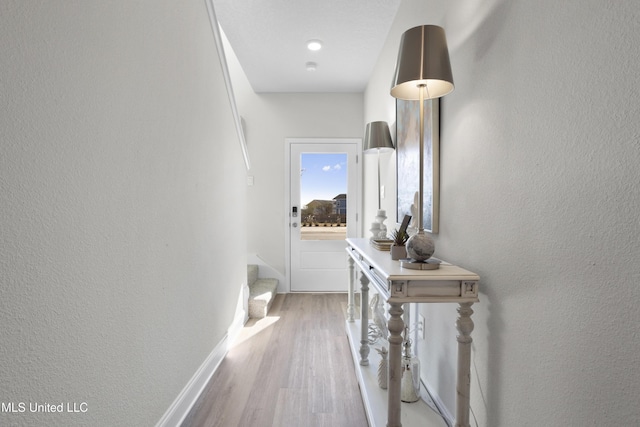 12278 Frazier Ln, Gulfport, MS 39503 - corridor featuring wood finished floors, stairs, a textured wall, and baseboards