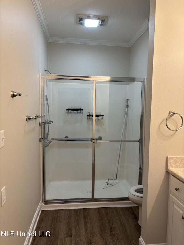 1405 Bay Ridge Dr, Gautier, MS 39553 - bathroom featuring wood finished floors, ornamental molding, vanity, a stall shower, and toilet