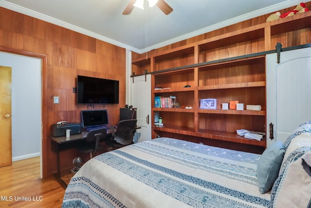 221 S Third St, Wiggins, MS 39577 - bedroom with a barn door, ornamental molding, and light wood-type flooring