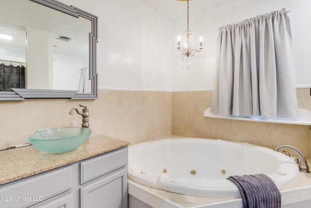 221 S Third St, Wiggins, MS 39577 - bathroom featuring vanity, a chandelier, and a jetted tub