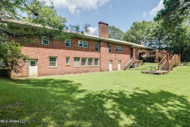 221 S Third St, Wiggins, MS 39577 - back of property with stairway, a chimney, a wooden deck, a lawn, and brick siding