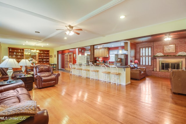 221 S Third St, Wiggins, MS 39577 - living room featuring ceiling fan, light wood-style floors, brick wall, a chandelier, and beam ceiling