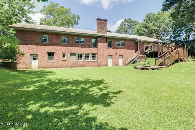 221 S Third St, Wiggins, MS 39577 - back of house with stairway, a chimney, a wooden deck, and a lawn