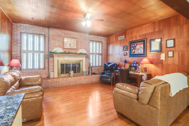 221 S Third St, Wiggins, MS 39577 - living room with wood finished floors, ceiling fan, wood ceiling, wood walls, and brick wall