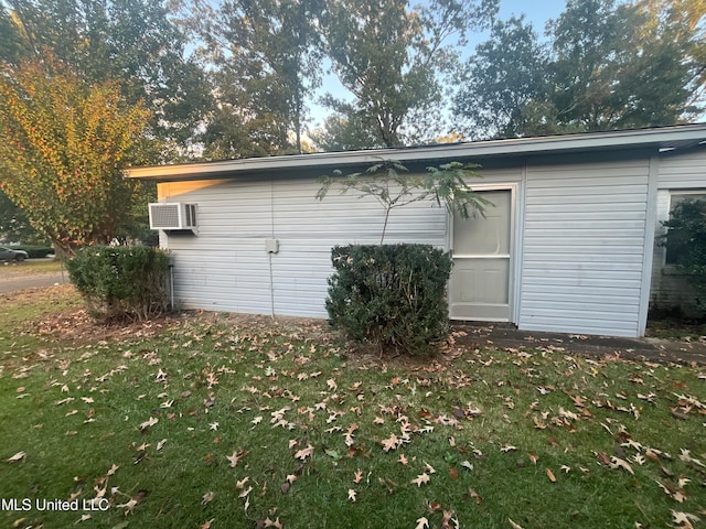 view of home's exterior featuring a wall unit AC and a yard