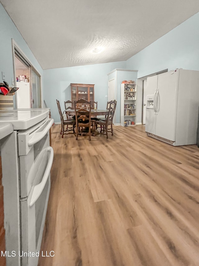 dining area featuring light hardwood / wood-style flooring and a textured ceiling