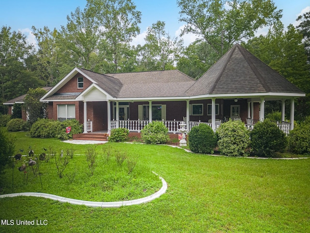view of front of house with covered porch, a shingled roof, a front lawn, and brick siding