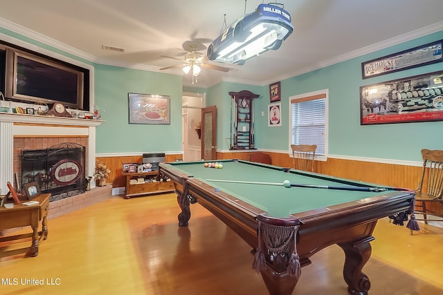 recreation room featuring pool table, a fireplace, light hardwood / wood-style floors, ceiling fan, and crown molding