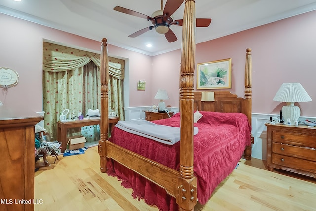 bedroom with crown molding, a wainscoted wall, ceiling fan, and wood finished floors