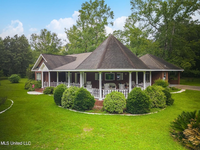 back of property featuring covered porch, a yard, and roof with shingles