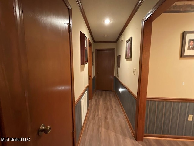 hall with light hardwood / wood-style flooring and ornamental molding