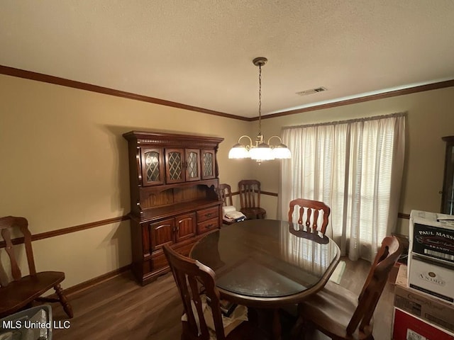 dining space with ornamental molding, a textured ceiling, an inviting chandelier, and dark wood-type flooring