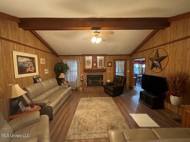 living room featuring vaulted ceiling with beams, ceiling fan, dark wood-type flooring, and wood walls