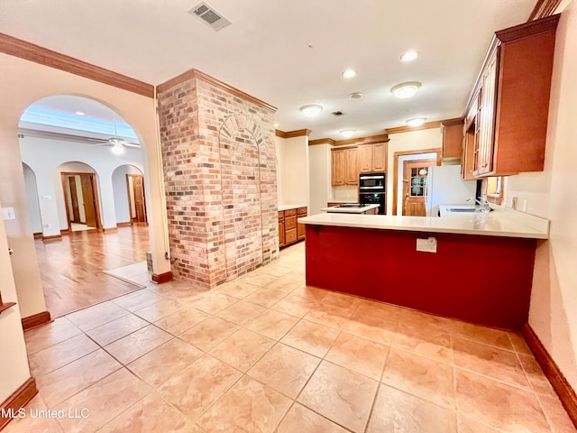 kitchen featuring oven, a breakfast bar area, crown molding, built in microwave, and ceiling fan