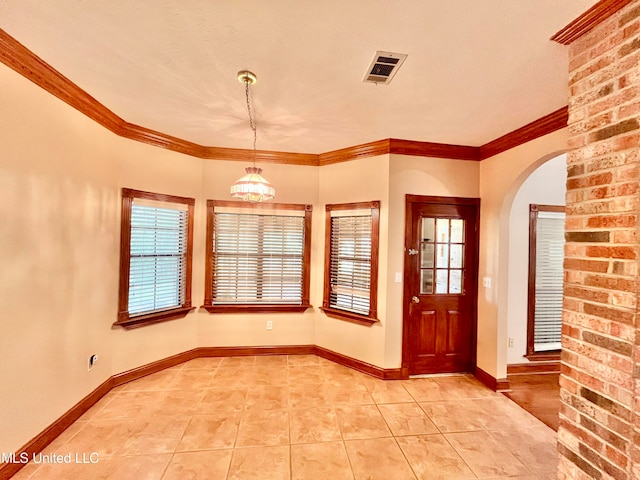 entrance foyer with a notable chandelier, ornamental molding, and a textured ceiling