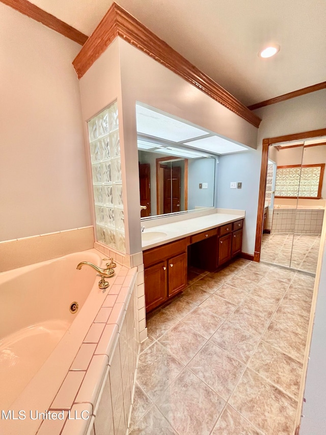 bathroom featuring vanity, ornamental molding, tiled tub, and tile patterned floors