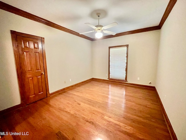 empty room featuring ornamental molding, hardwood / wood-style floors, and ceiling fan