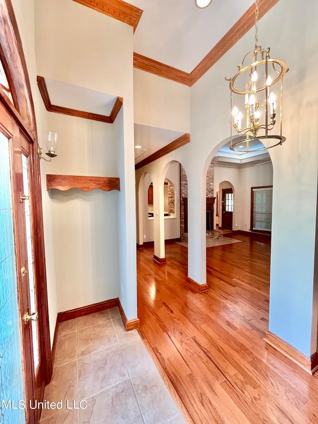 hallway with crown molding, light wood-type flooring, and french doors