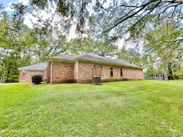 view of side of home with a storage shed and a yard