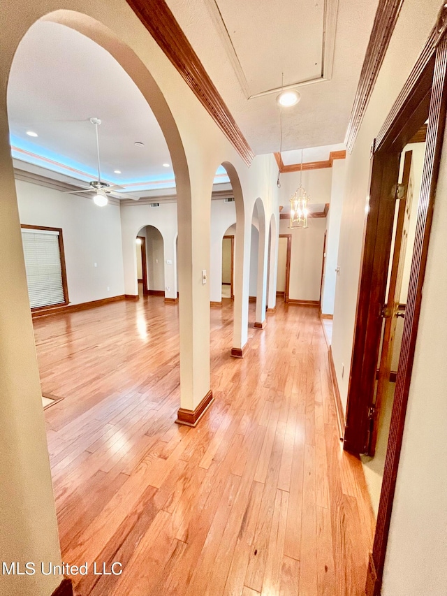 hall with ornamental molding and light wood-type flooring