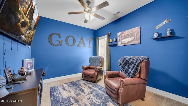 living area featuring carpet flooring and ceiling fan