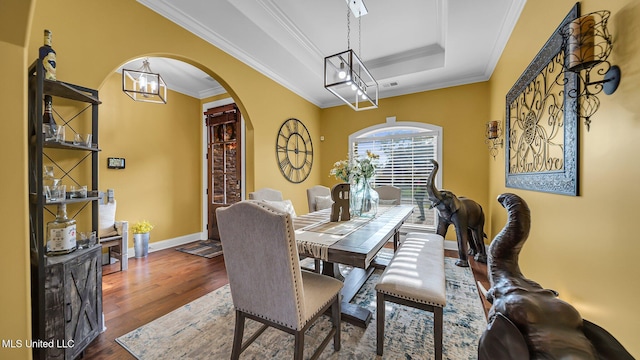 dining room featuring hardwood / wood-style floors, crown molding, and a tray ceiling