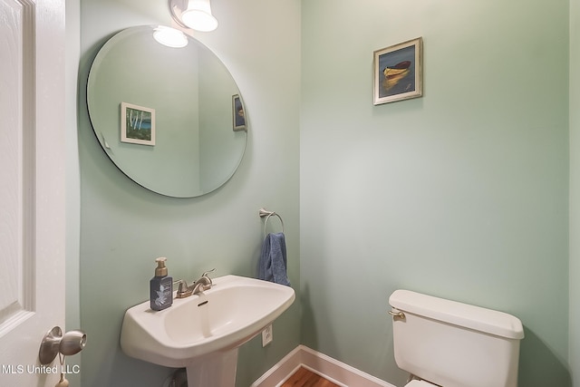 bathroom featuring hardwood / wood-style flooring, toilet, and sink