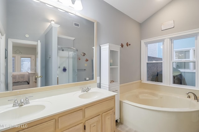 bathroom with shower with separate bathtub, vanity, vaulted ceiling, and a healthy amount of sunlight