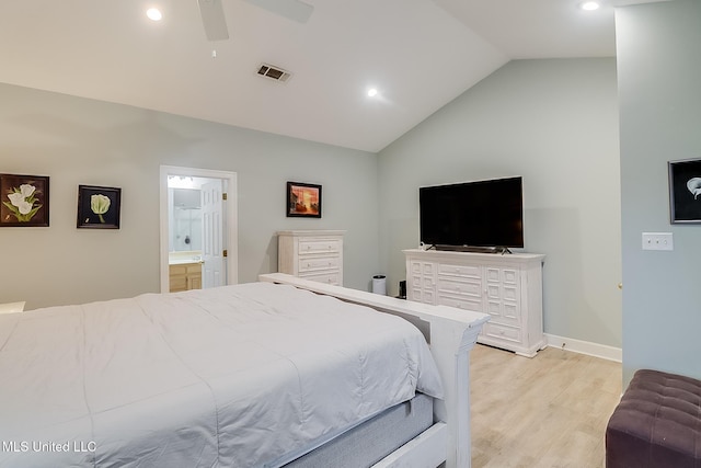 bedroom featuring light wood-type flooring, ensuite bathroom, ceiling fan, and lofted ceiling