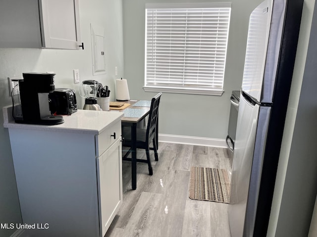 office space with electric panel and light wood-type flooring