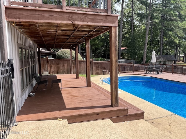 view of pool featuring a patio area and a wooden deck