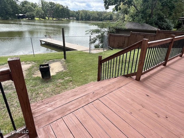 wooden terrace featuring a water view and a lawn