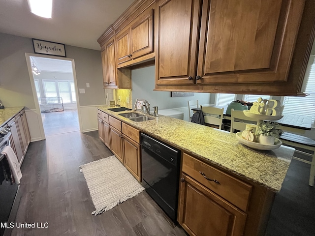 kitchen featuring light stone counters, dark hardwood / wood-style flooring, stainless steel stove, dishwasher, and sink