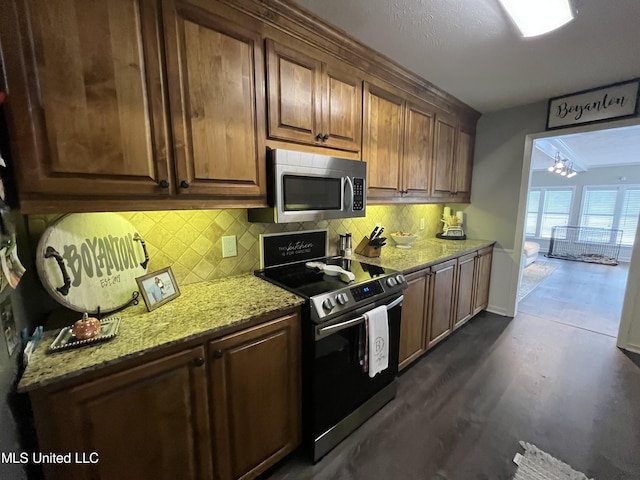 kitchen featuring backsplash, stainless steel appliances, light stone counters, and dark hardwood / wood-style flooring