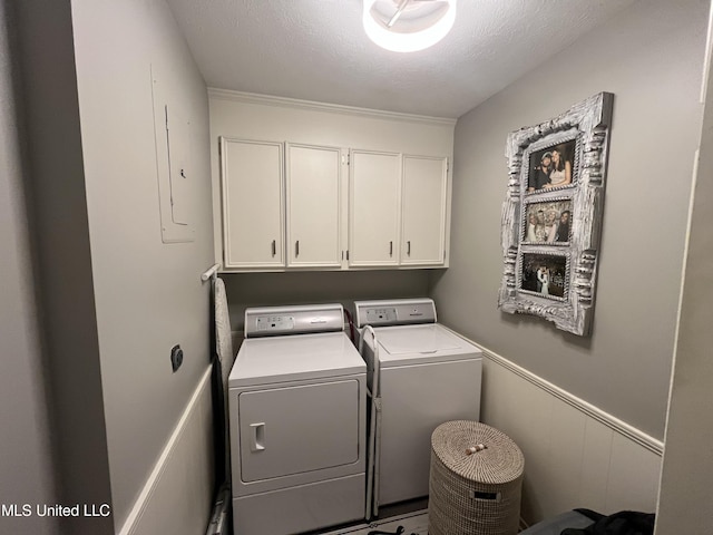 laundry area with cabinets, a textured ceiling, and washing machine and dryer