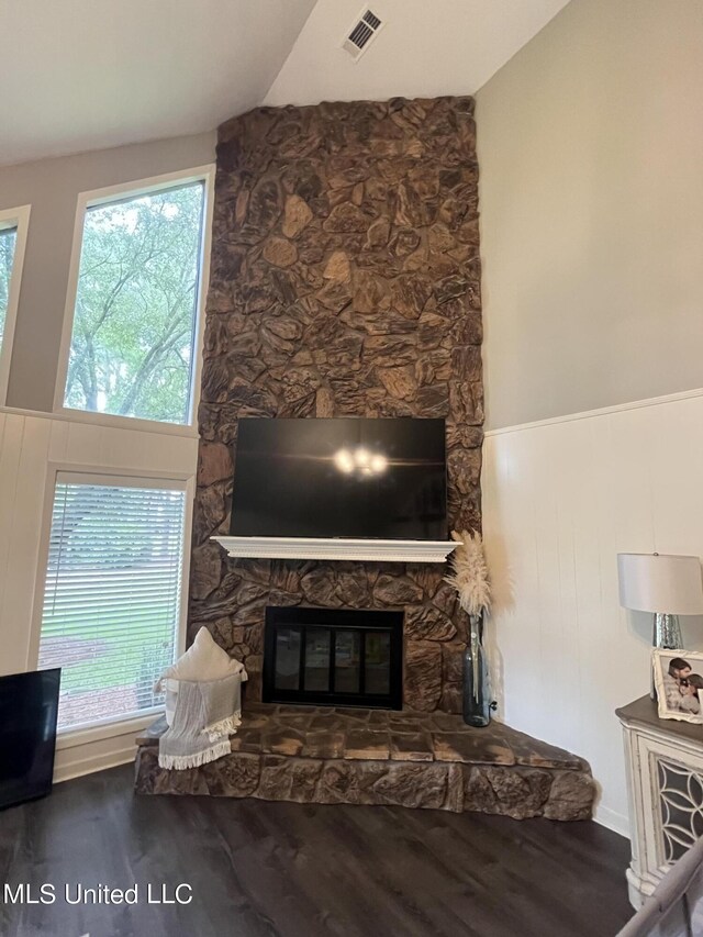 living room with a stone fireplace, lofted ceiling, and hardwood / wood-style floors