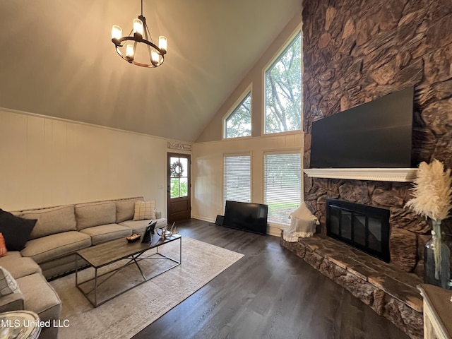 living room featuring high vaulted ceiling, a stone fireplace, an inviting chandelier, and dark hardwood / wood-style floors