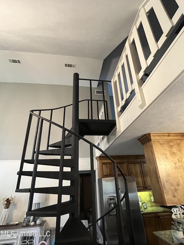 stairs with a textured ceiling