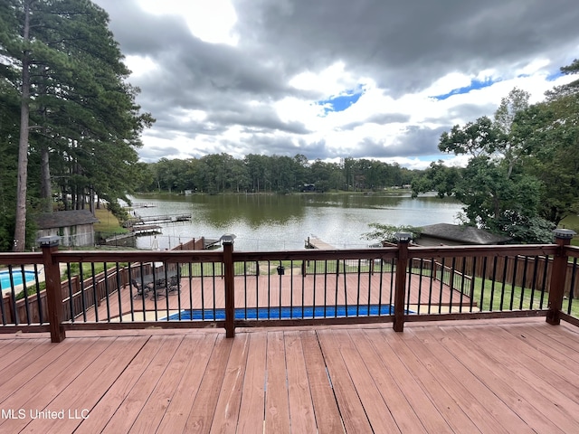 wooden terrace featuring a water view and a swimming pool