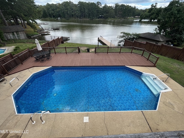 view of pool featuring a deck with water view and a lawn