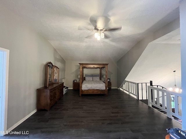 living area featuring vaulted ceiling, a textured ceiling, dark hardwood / wood-style flooring, and ceiling fan with notable chandelier