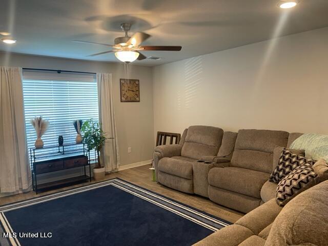 living room featuring hardwood / wood-style floors and ceiling fan