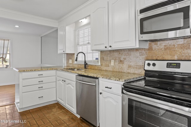 kitchen with sink, white cabinetry, stainless steel appliances, and tasteful backsplash