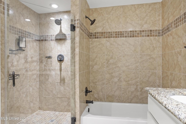 bathroom featuring vanity and tiled shower / bath