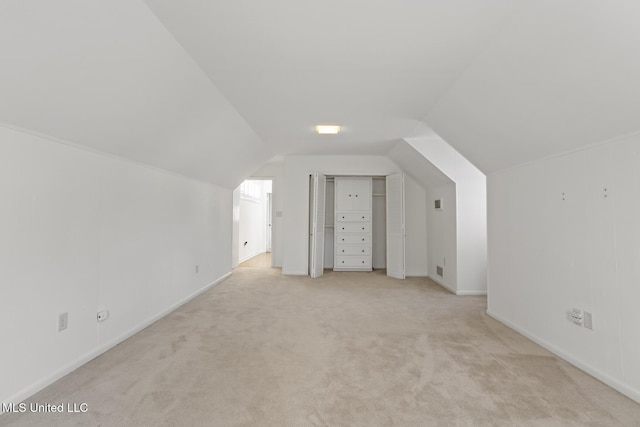 bonus room featuring light carpet and vaulted ceiling