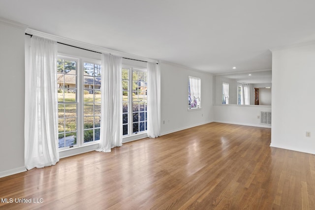 empty room featuring hardwood / wood-style flooring and ornamental molding