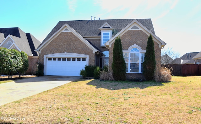 traditional-style house featuring a garage, a front yard, brick siding, and driveway